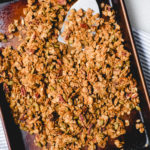 turning cooked granola in a small sheet pan