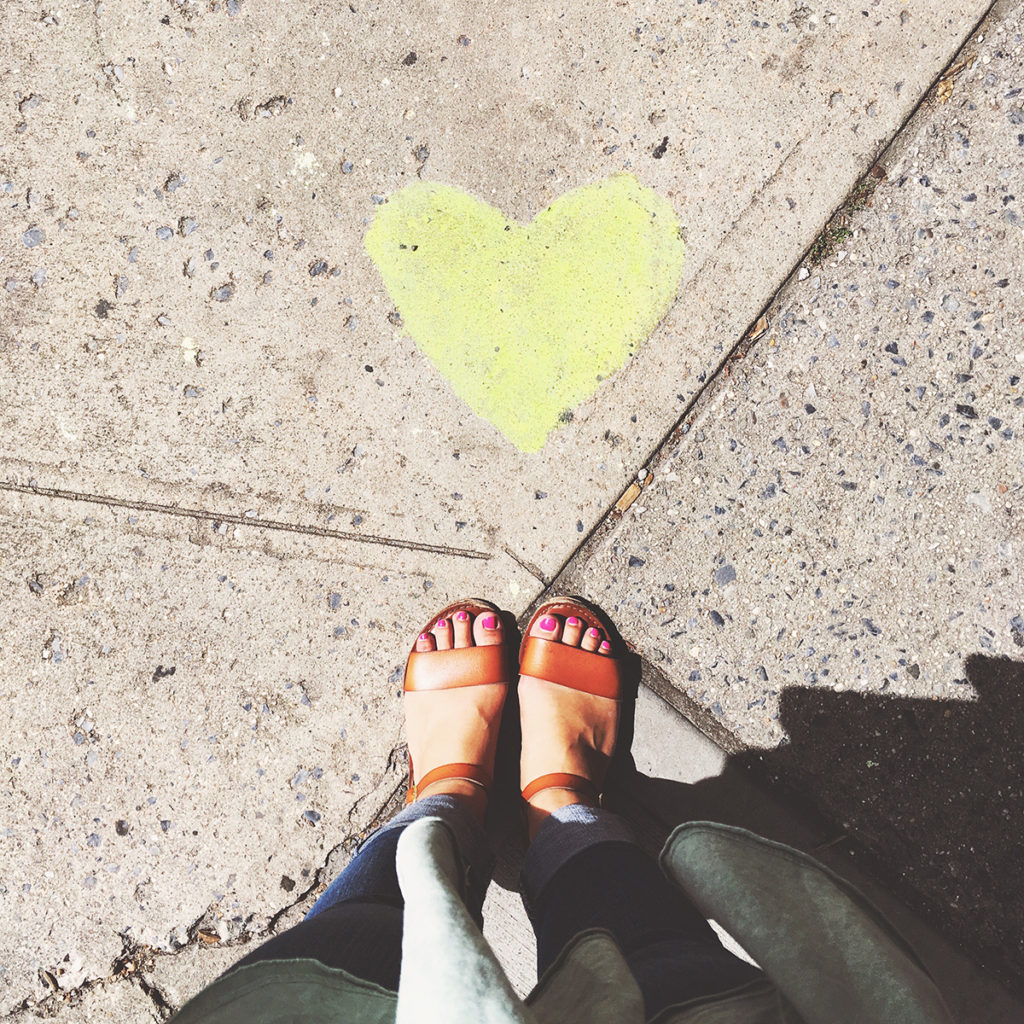 sandals next to heart on the sidewalk in new york city