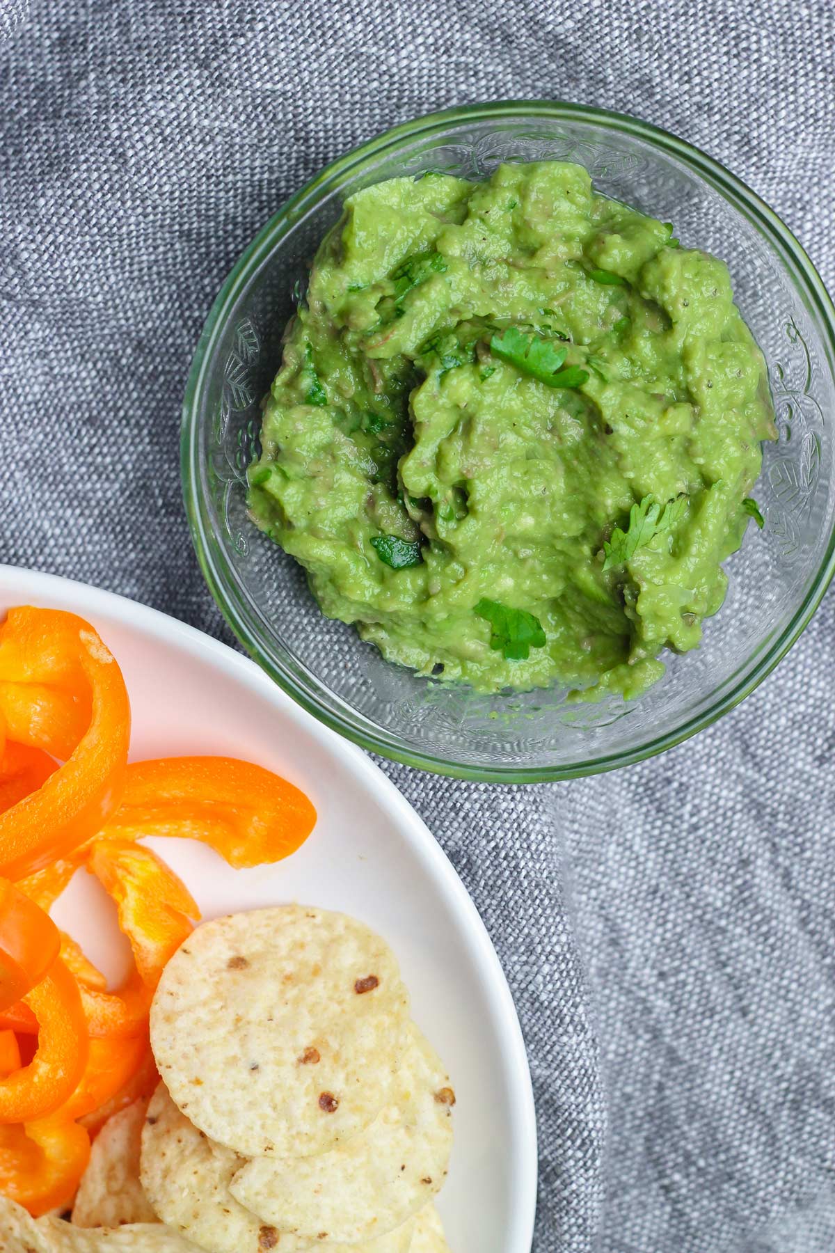 small bowl of five ingredient guacamole with chips and bell peppers
