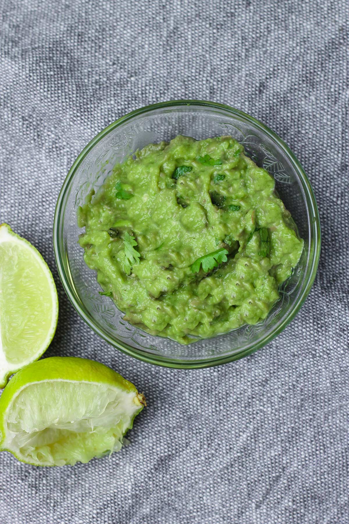 small bowl of guacamole with squeezed limes