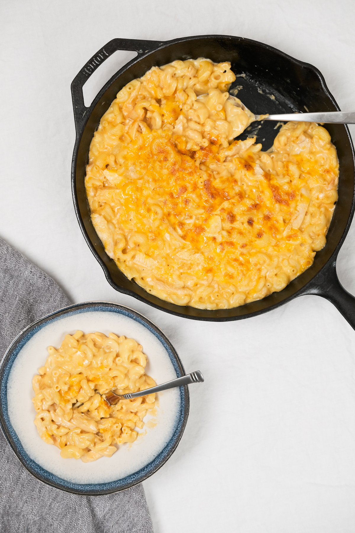 scooping out buffalo chicken mac and cheese from a skillet