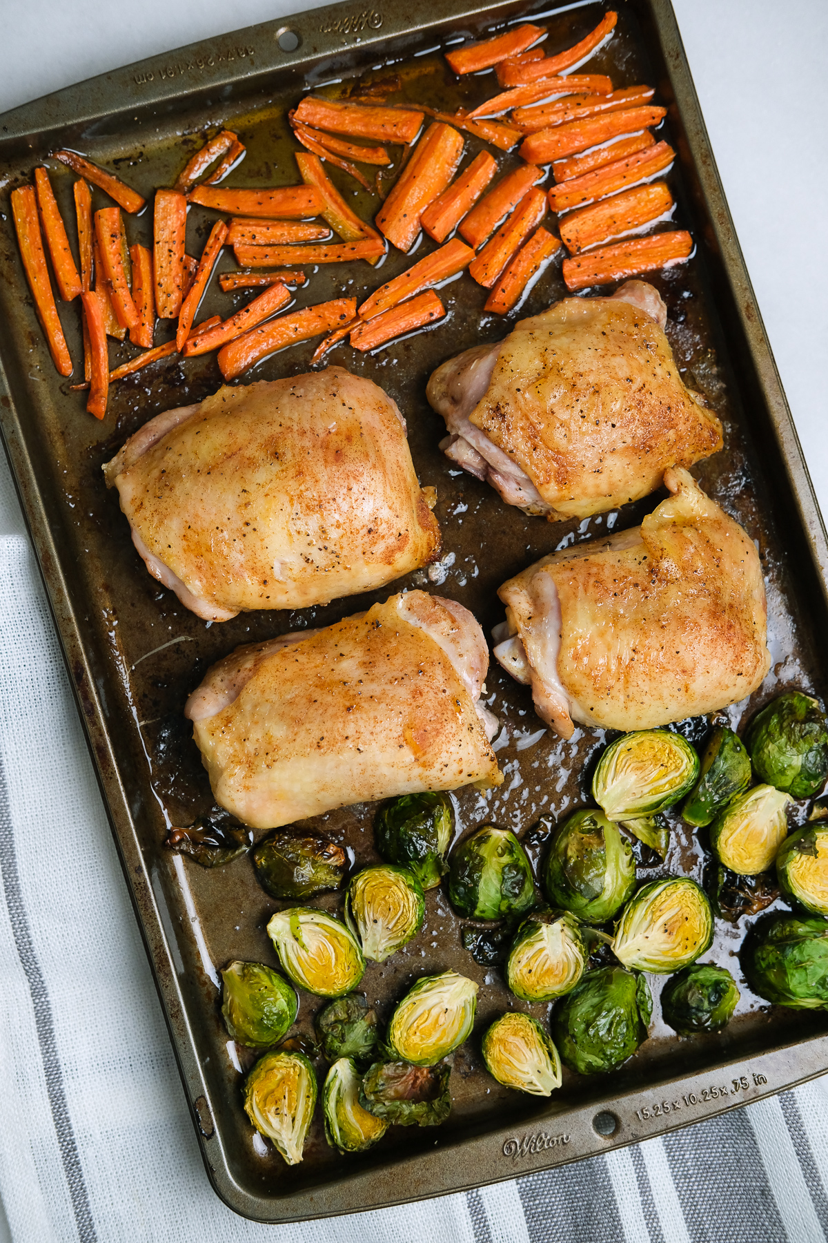 chicken thighs and roasted vegetables on a sheet pan