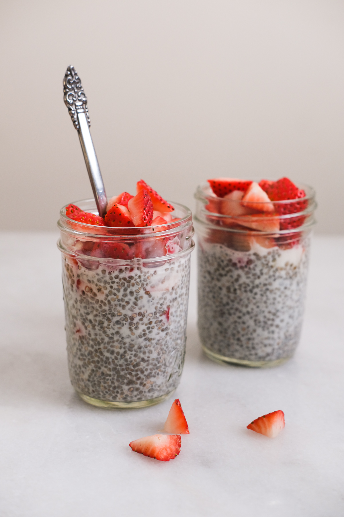 two jars of chia seed pudding with fresh strawberries