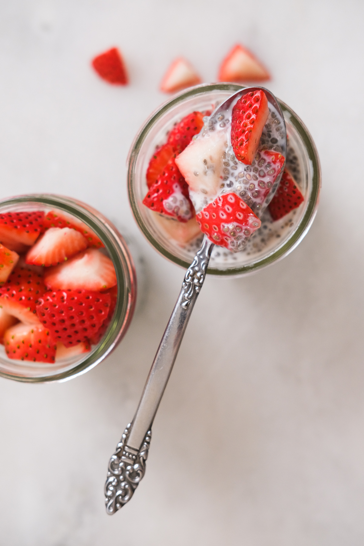 scooping out chia seed pudding with fresh strawberries