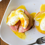 cut open eggs benedict on a plate