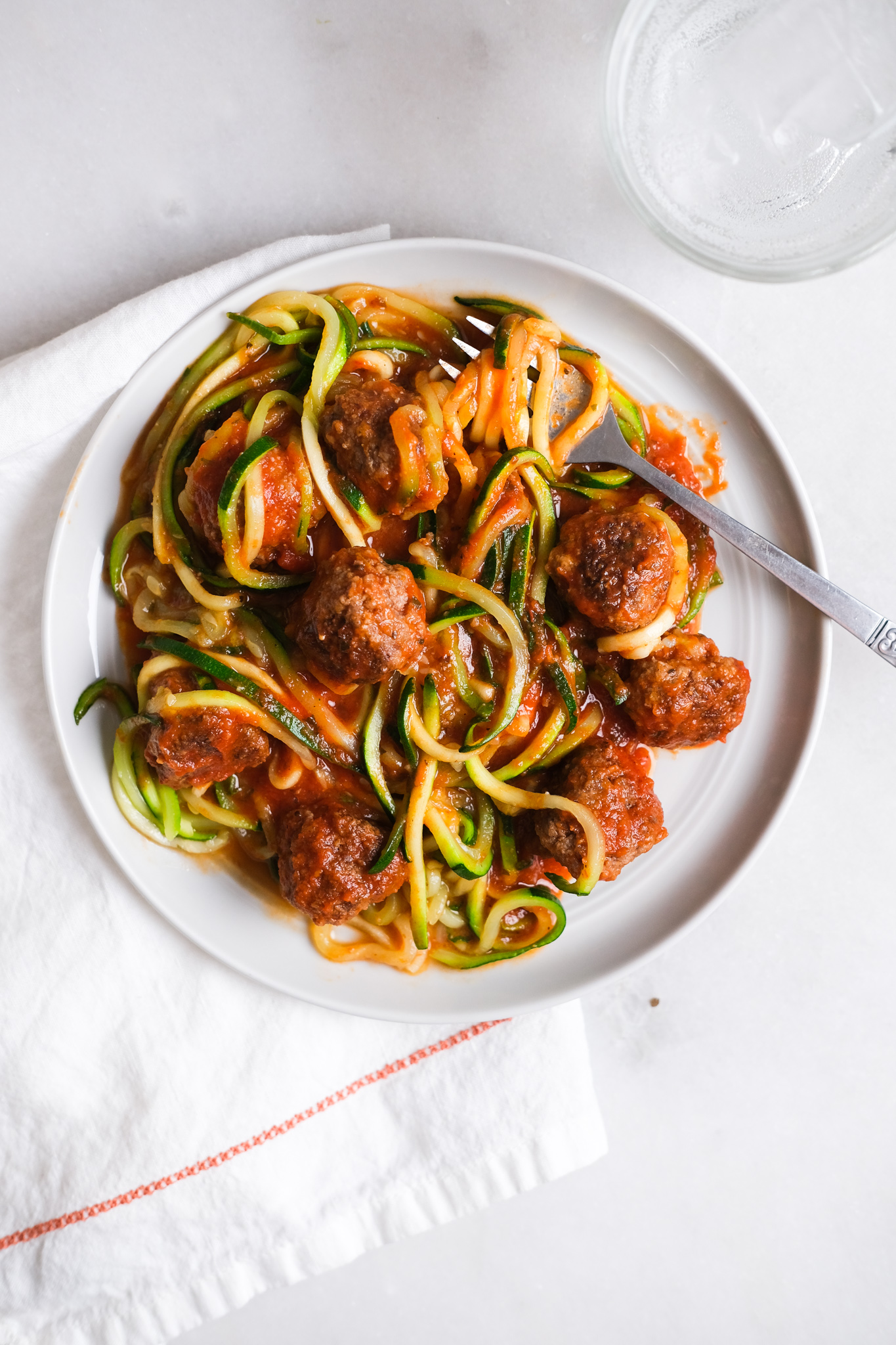 zoodles with meatballs on a gray plate