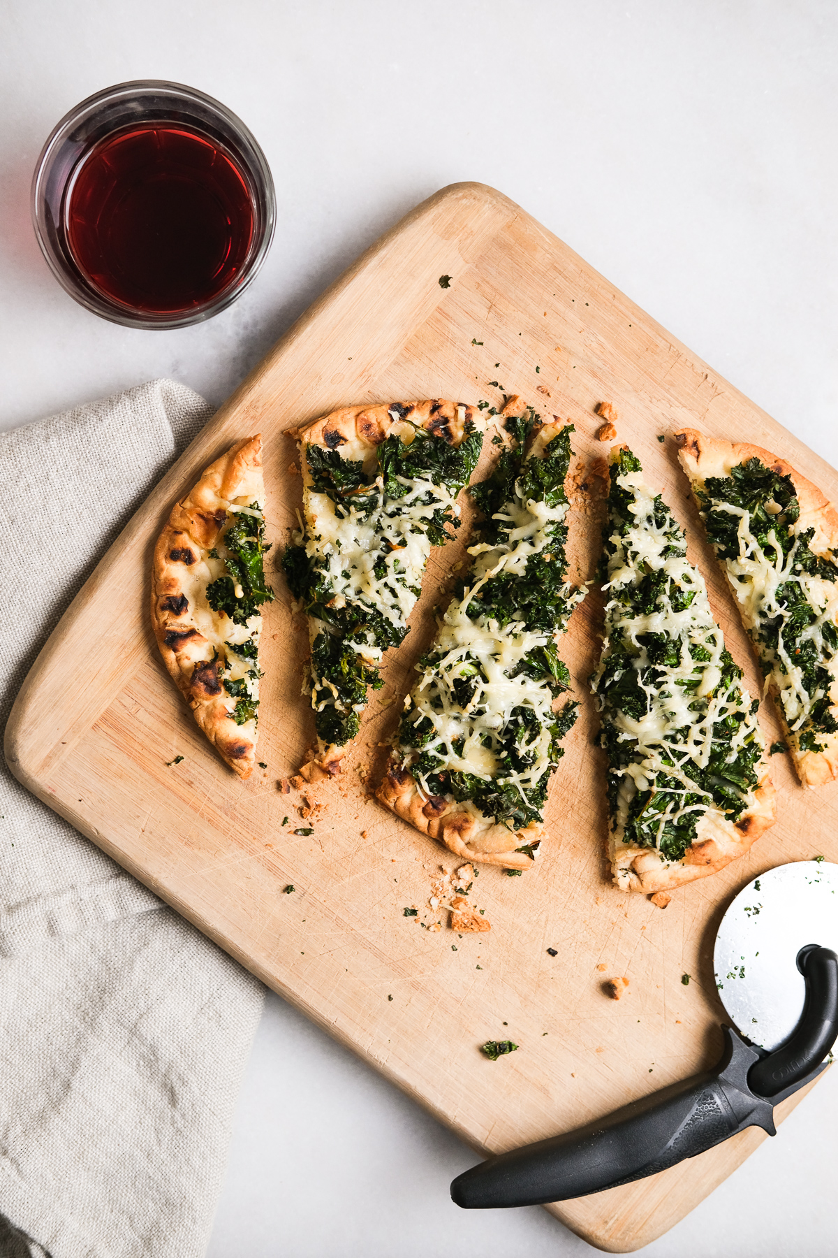 slices of kale parmesan flatbread pizza with wine