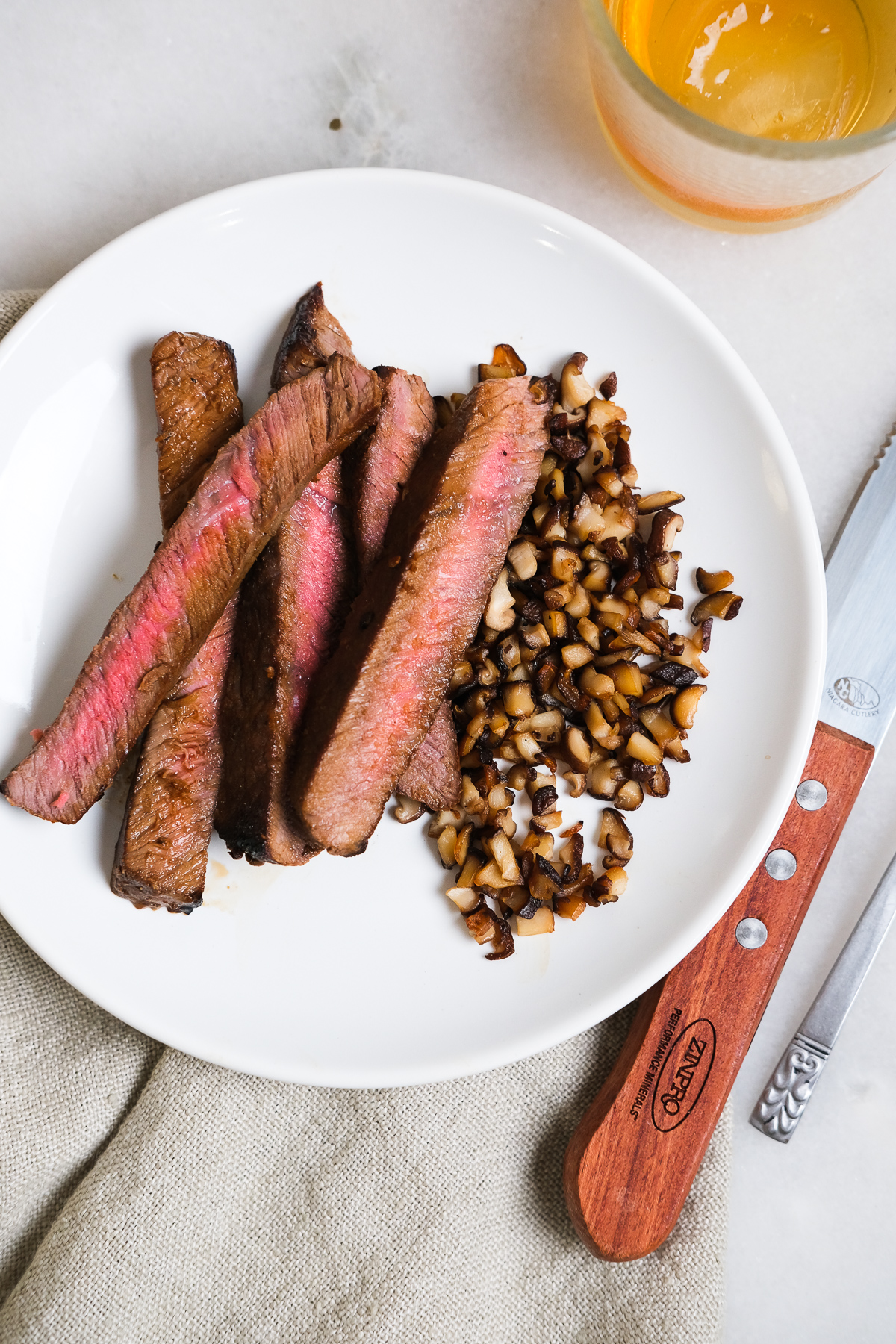 london broil strips on a plate with shiitake mushrooms