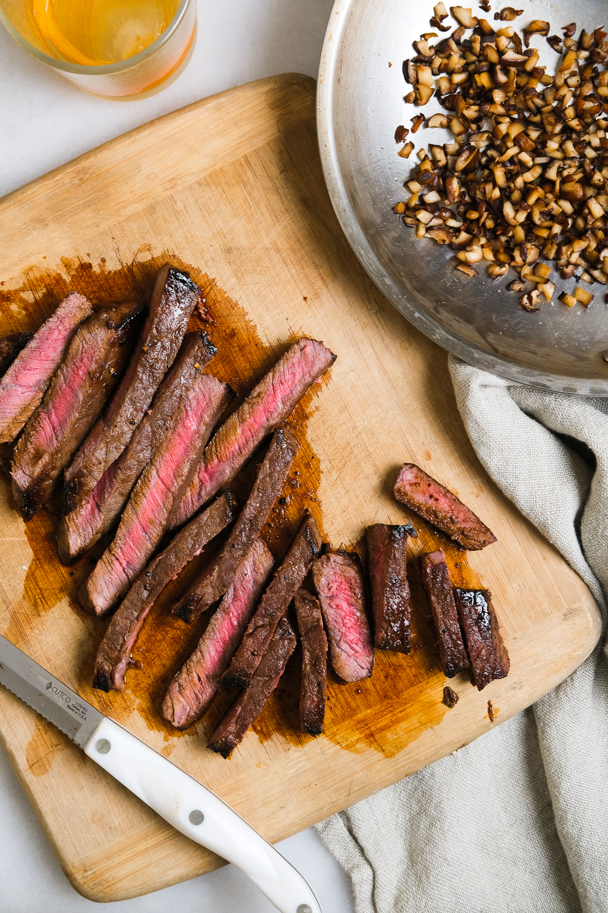 london broil cut up on a cutting board with small mushroom bites