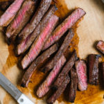 close up of london broil sliced up on a cutting board