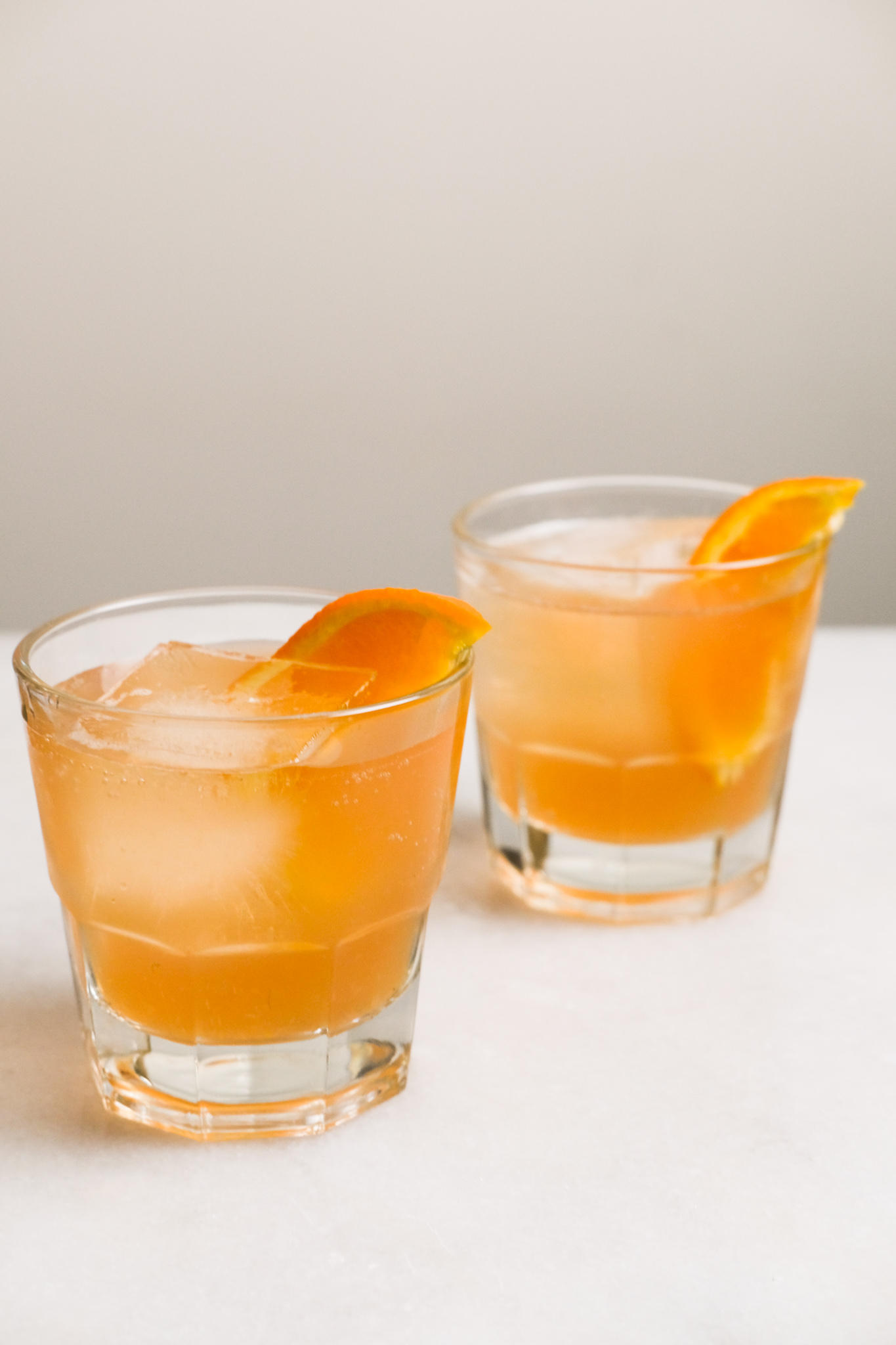 two glasses of orange cranberry bourbon cocktails