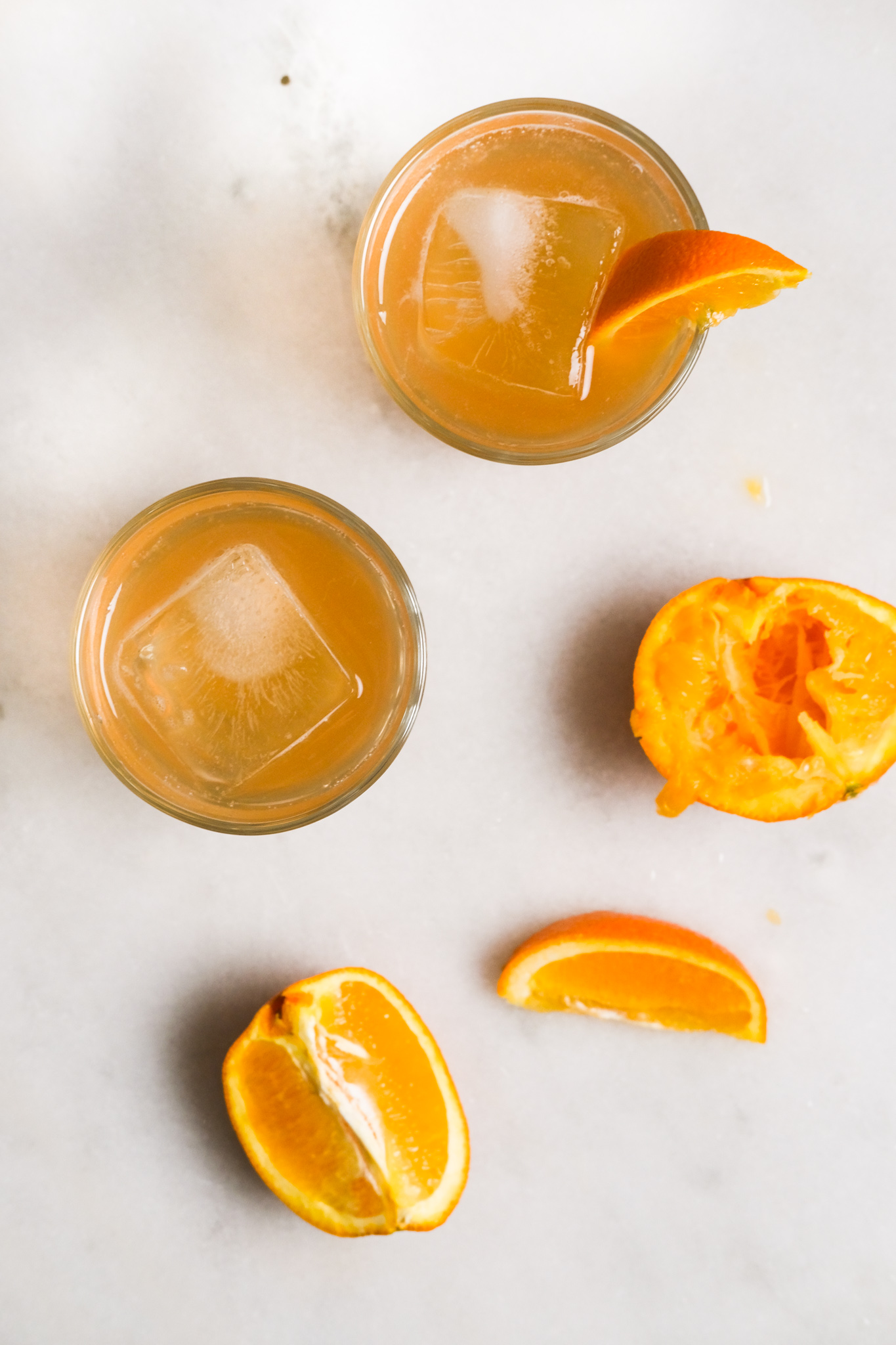 adding orange slices to orange cranberry bourbon cocktails