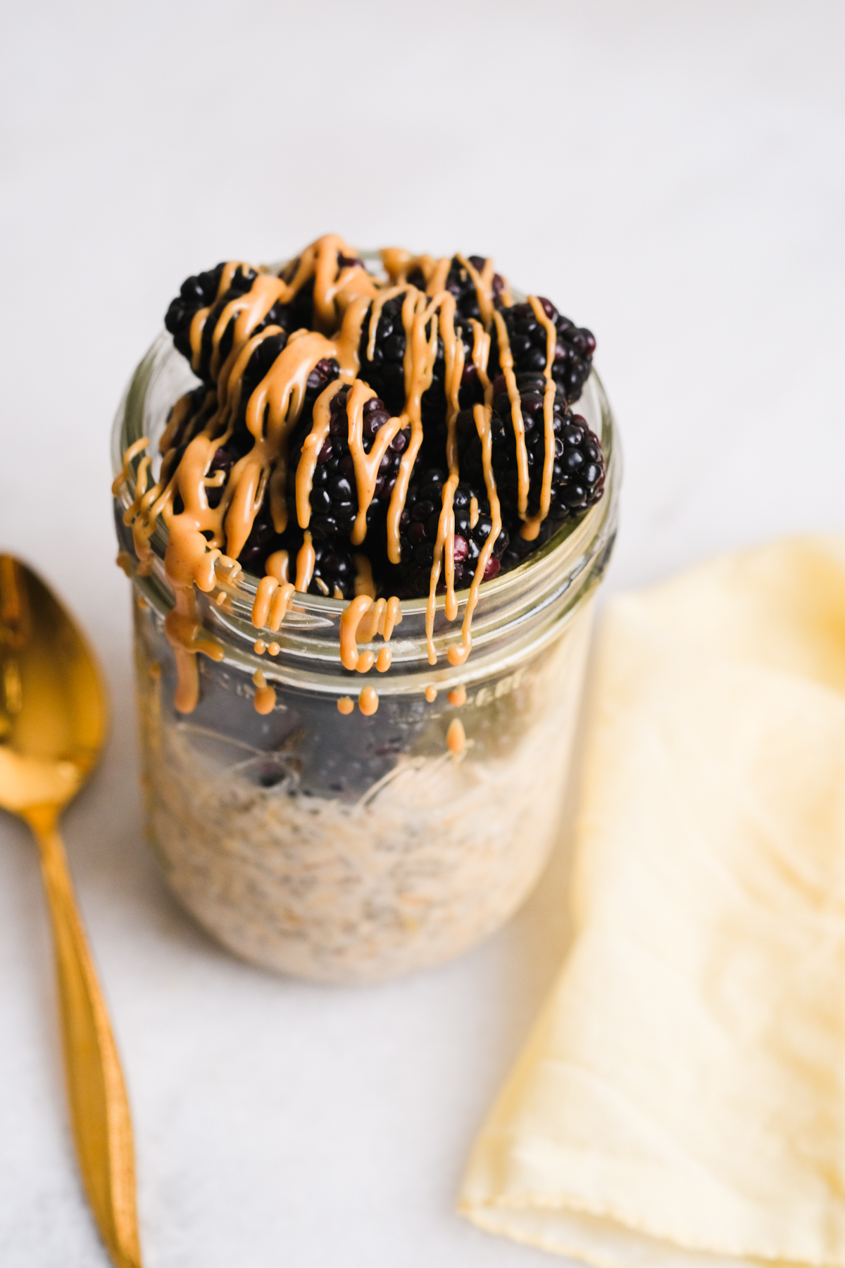 peanut butter overnight oats with blackberries and drizzled peanut butter