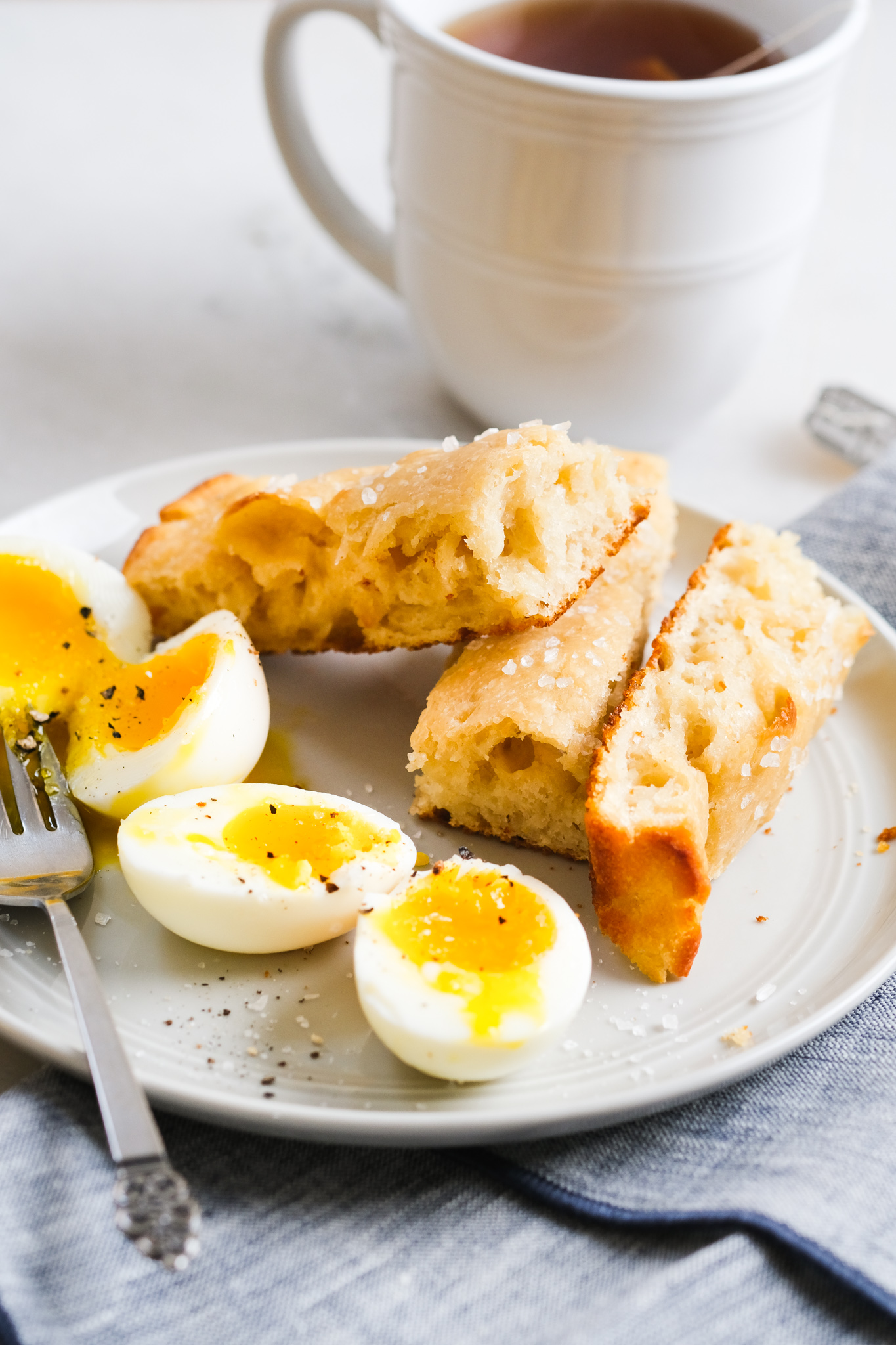 sourdough focaccia with soft boiled eggs and tea for breakfast