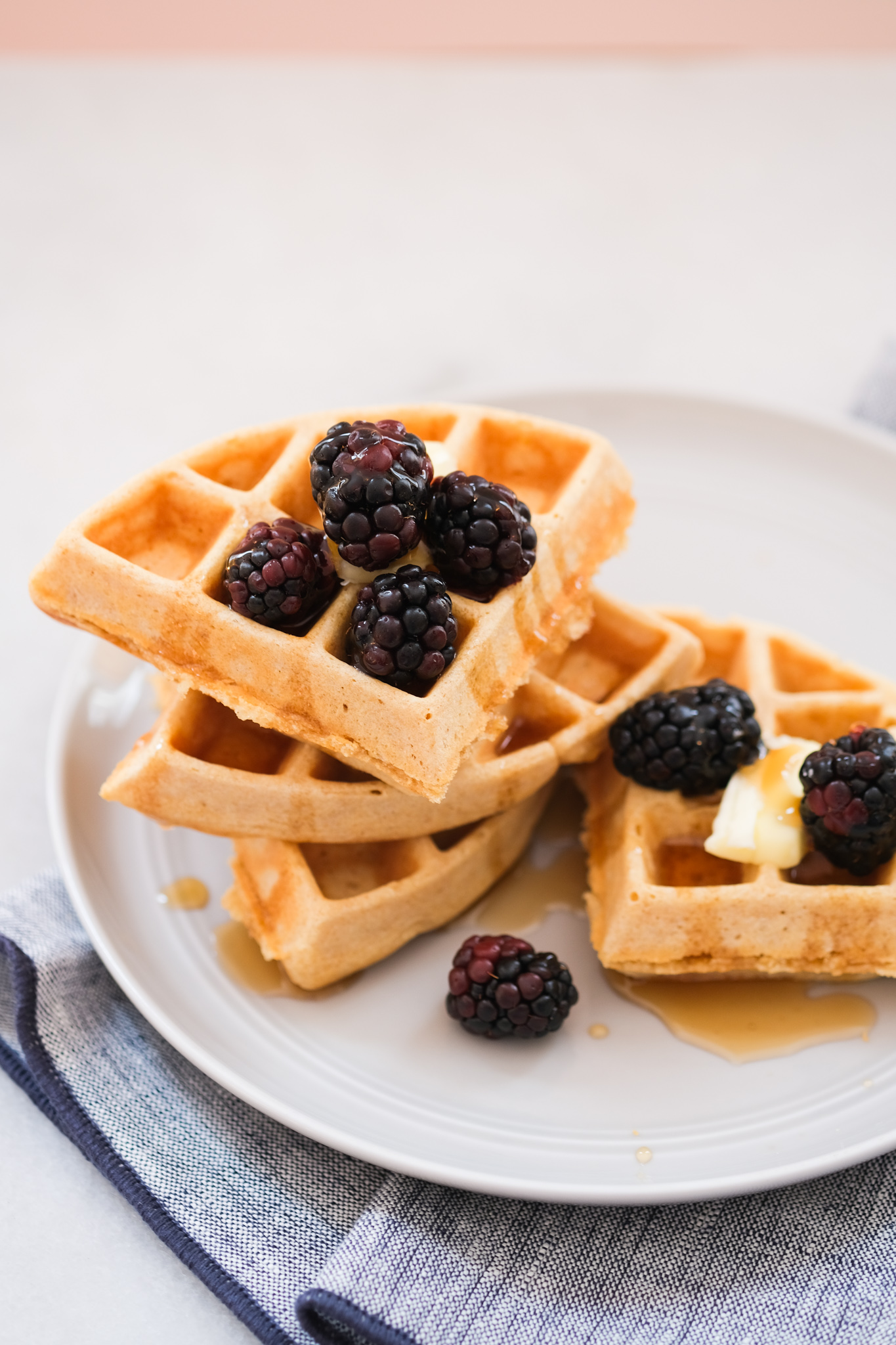 stacked whole wheat waffles with berries and butter