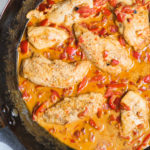 chicken with creamy roasted red pepper sauce in a skillet