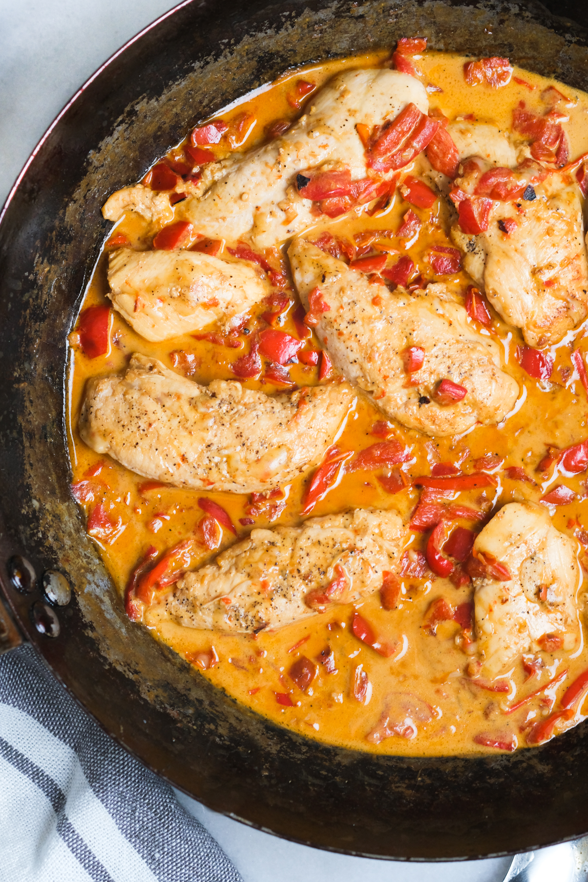 chicken with creamy roasted red pepper sauce in a skillet
