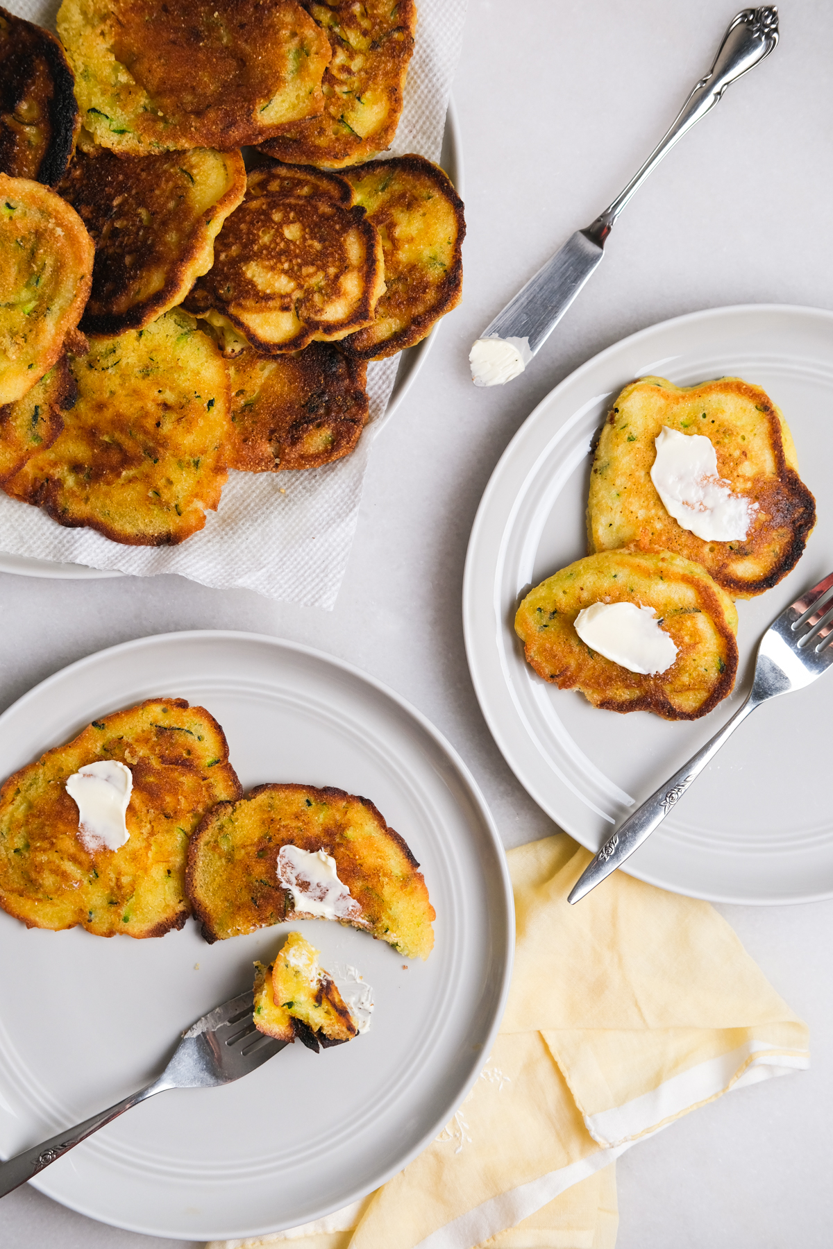 zucchini fritters on plates with spreadable butter