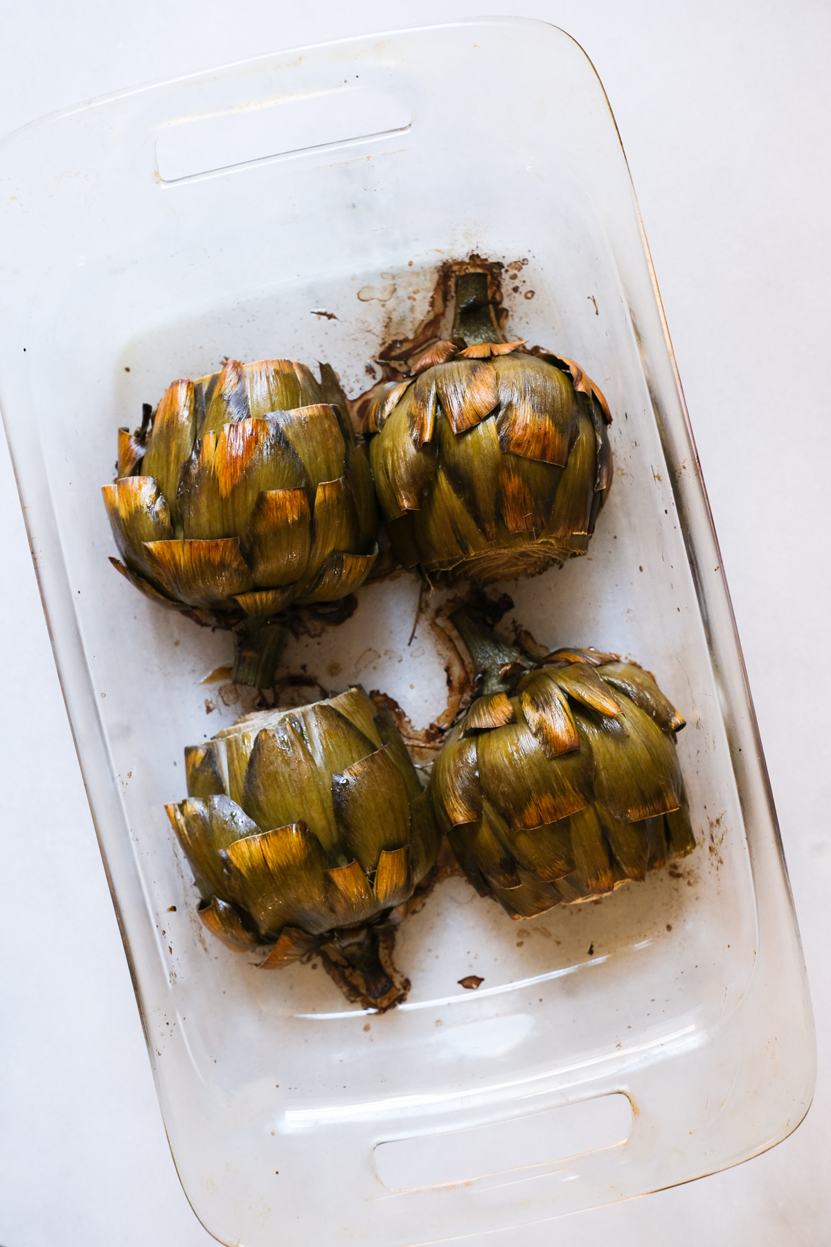 roasted artichokes in a glass dish