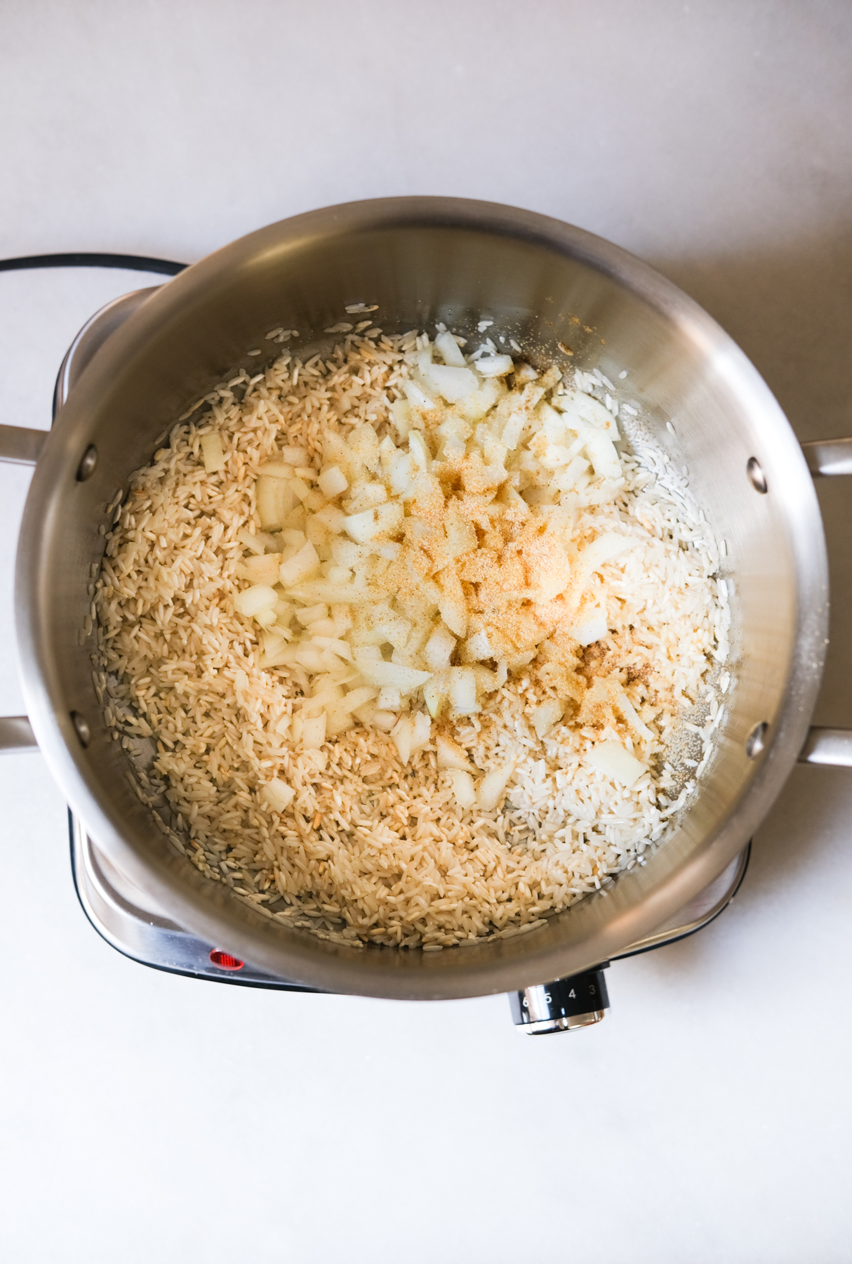 adding in onions and seasoning with pre-cooked rice for Mexican rice