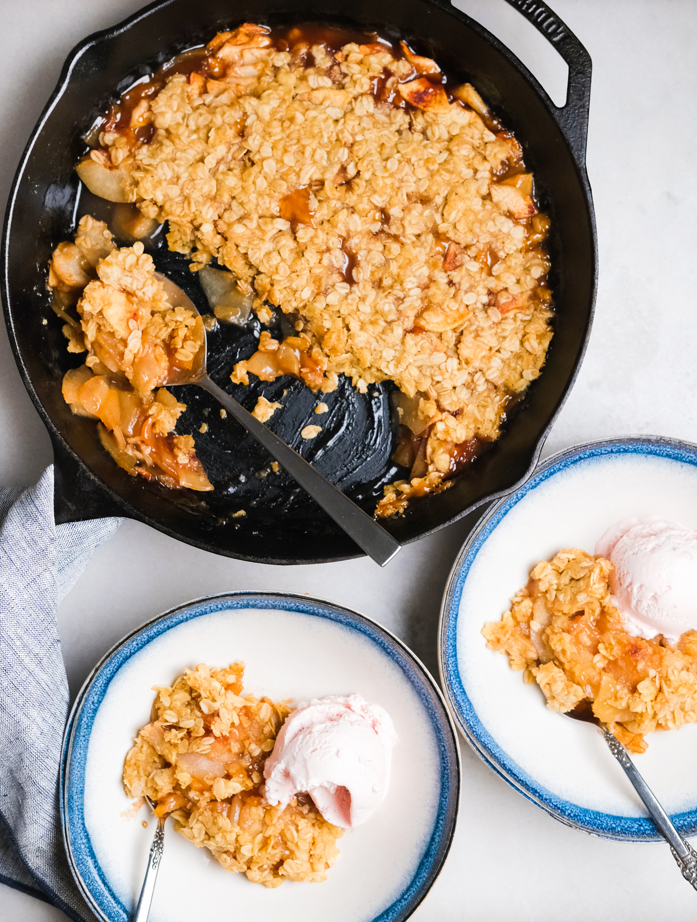 apple pear crisp in a cast iron skillet with bowls