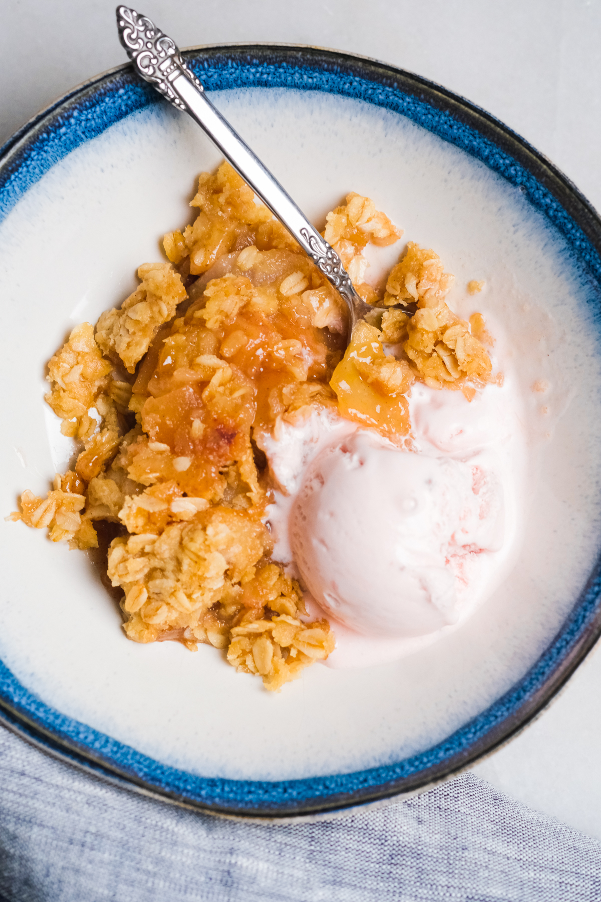 apple pear crisp in a bowl with strawberry ice cream