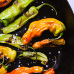 blistered shishito peppers in a skillet