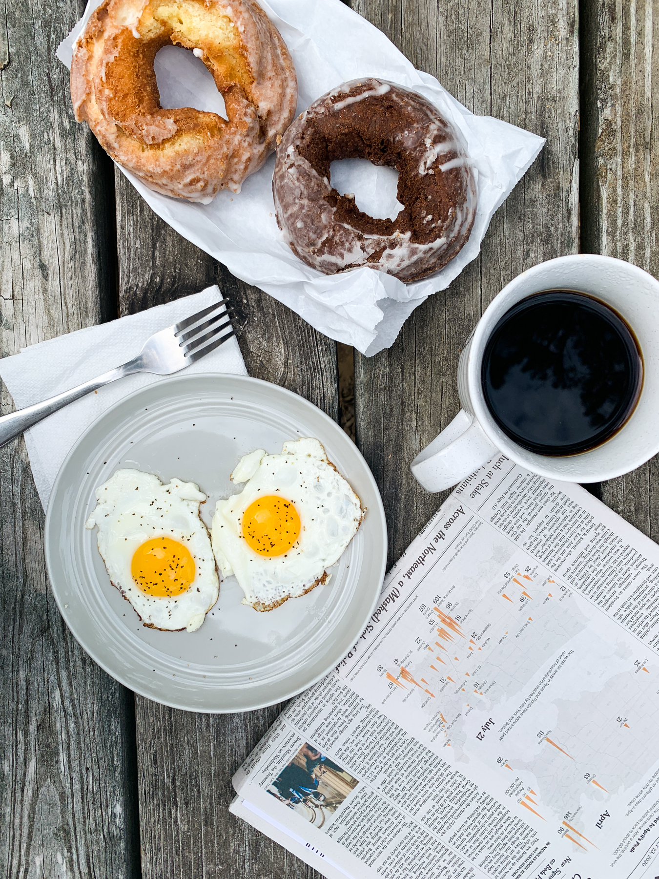 fresh baked donuts with fried eggs on a picnic table with coffee