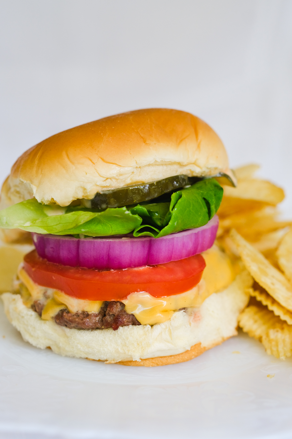 classic cheeseburger with chips on a plate