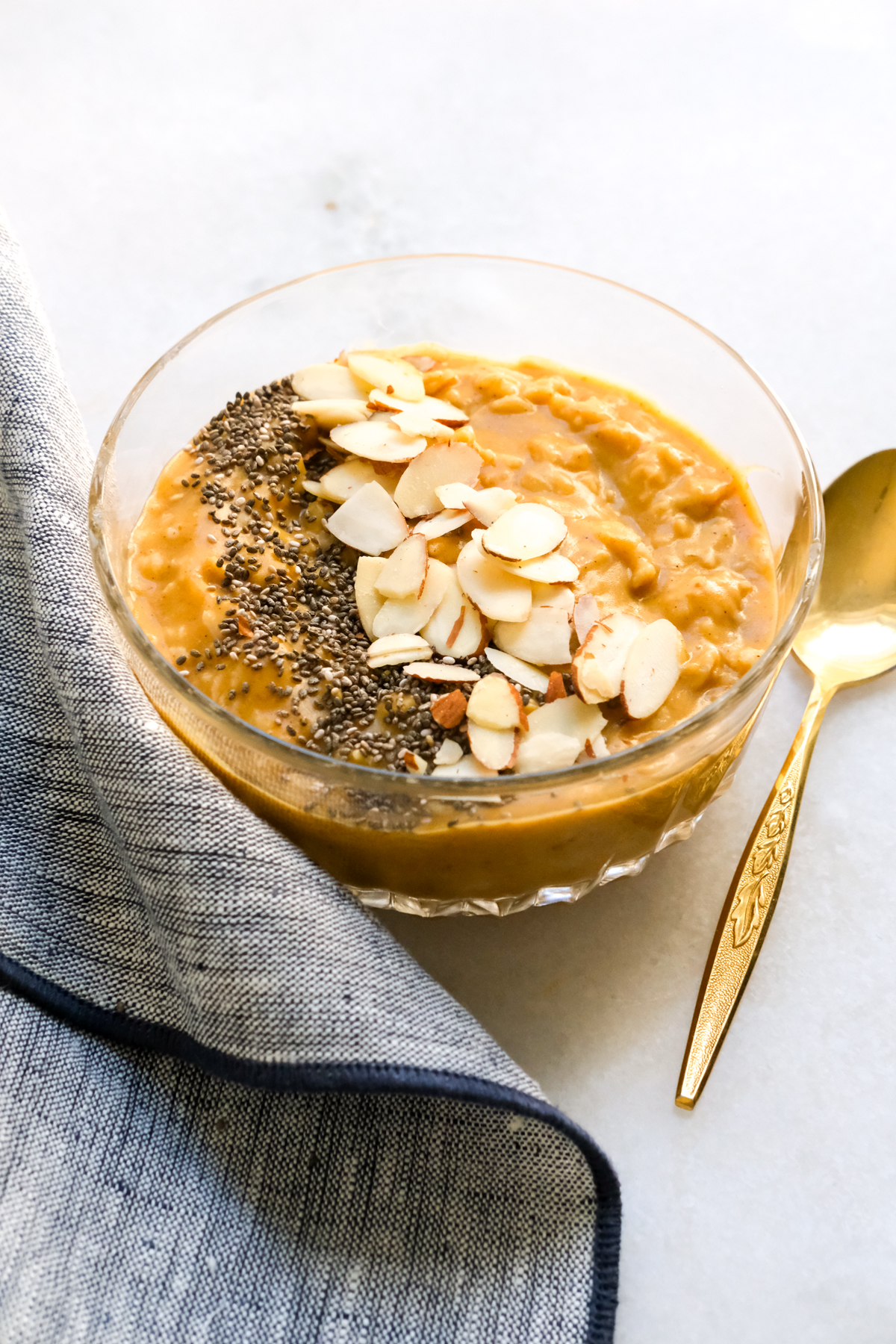 pumpkin oatmeal in a bowl with sliced almonds and chia seeds