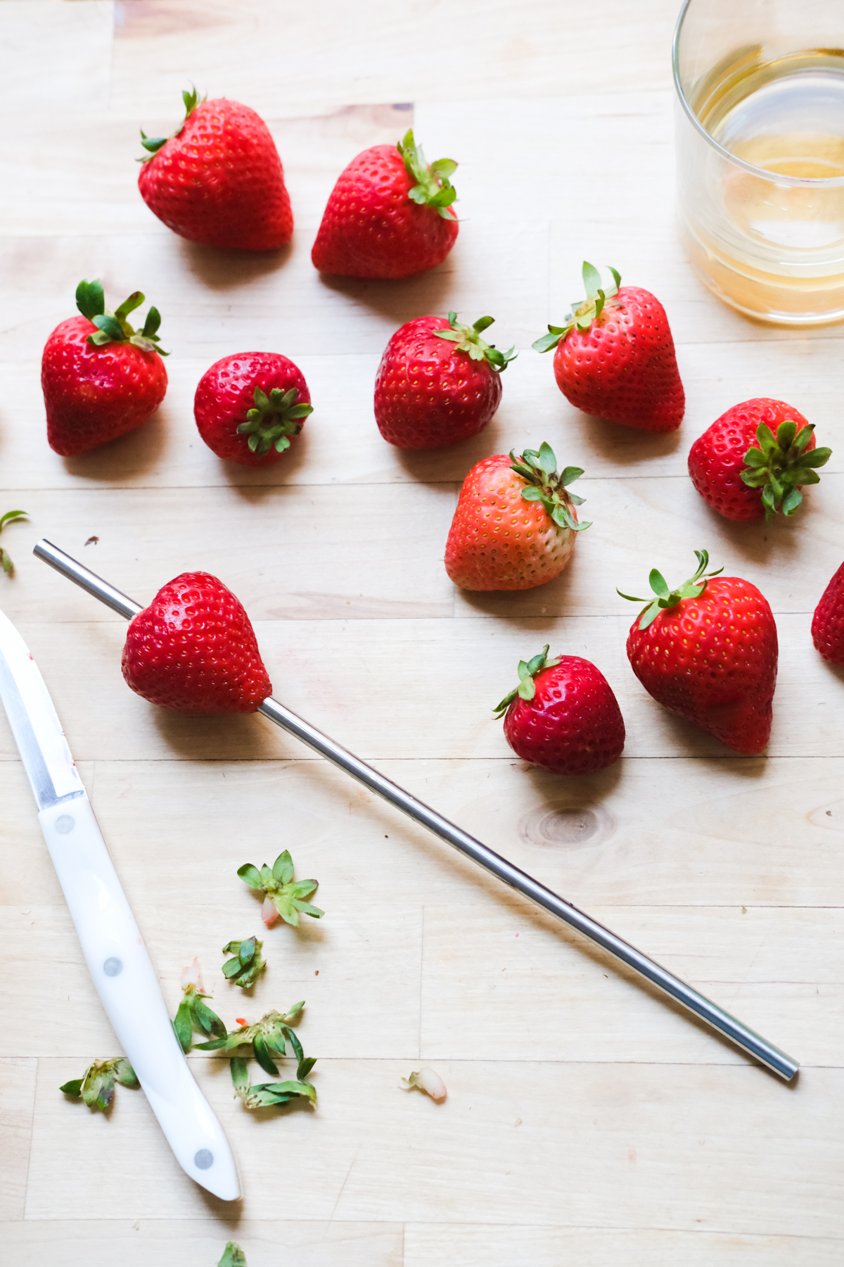 hulling strawberries with a straw