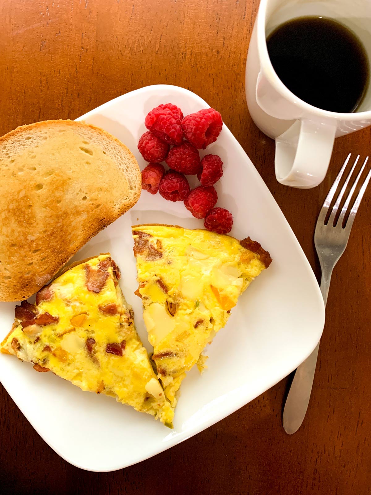 slices of frittata on a plate with toast and berries