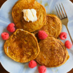pumpkin pancakes on a plate with raspberries