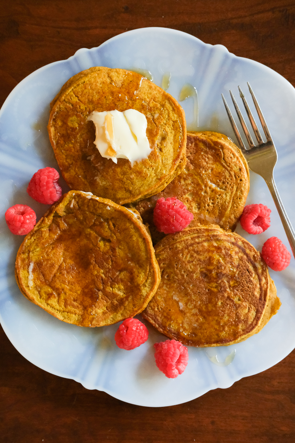pumpkin pancakes on a plate with raspberries
