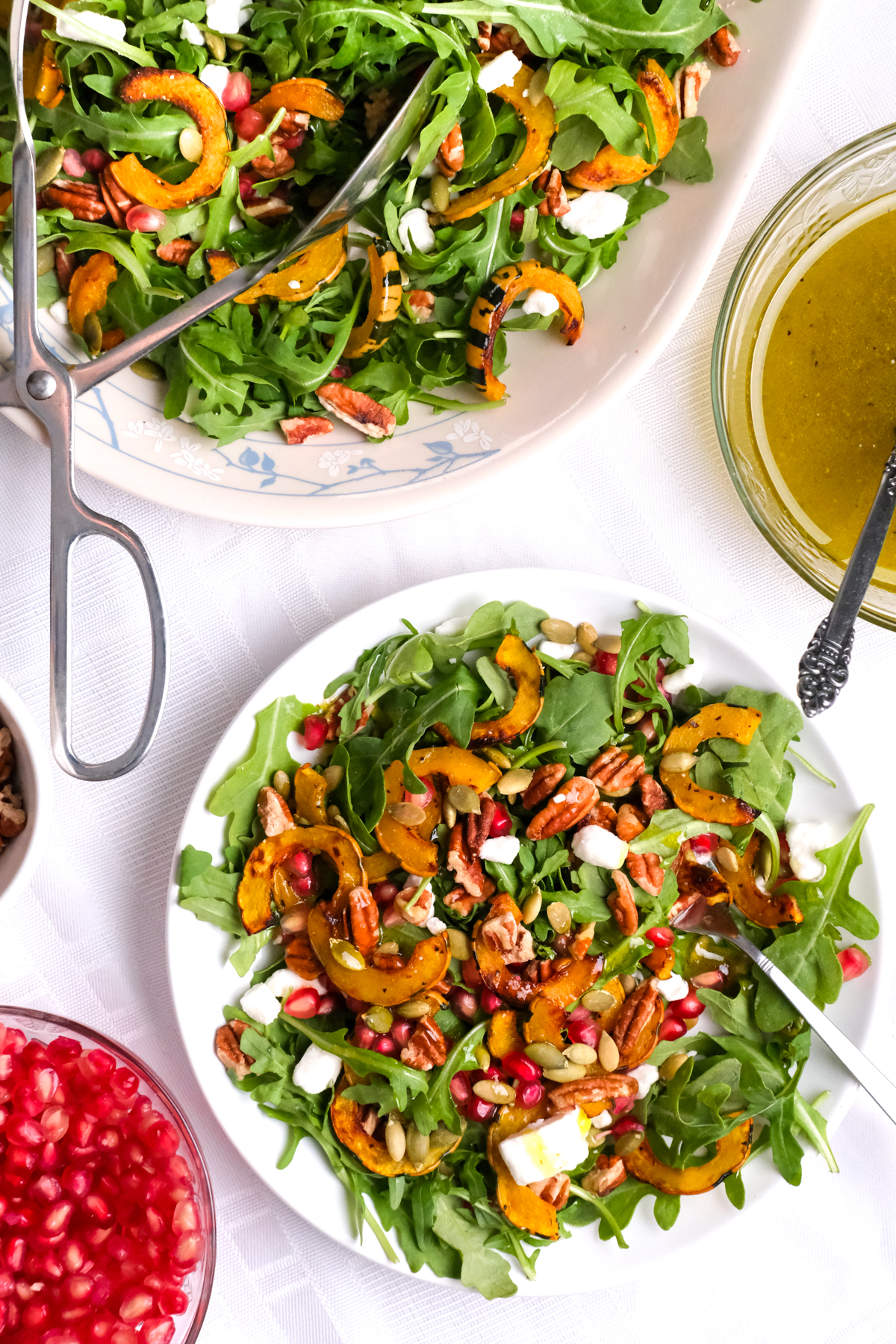 delicata squash salad on a plate with a side of apple cider vinaigrette dressing