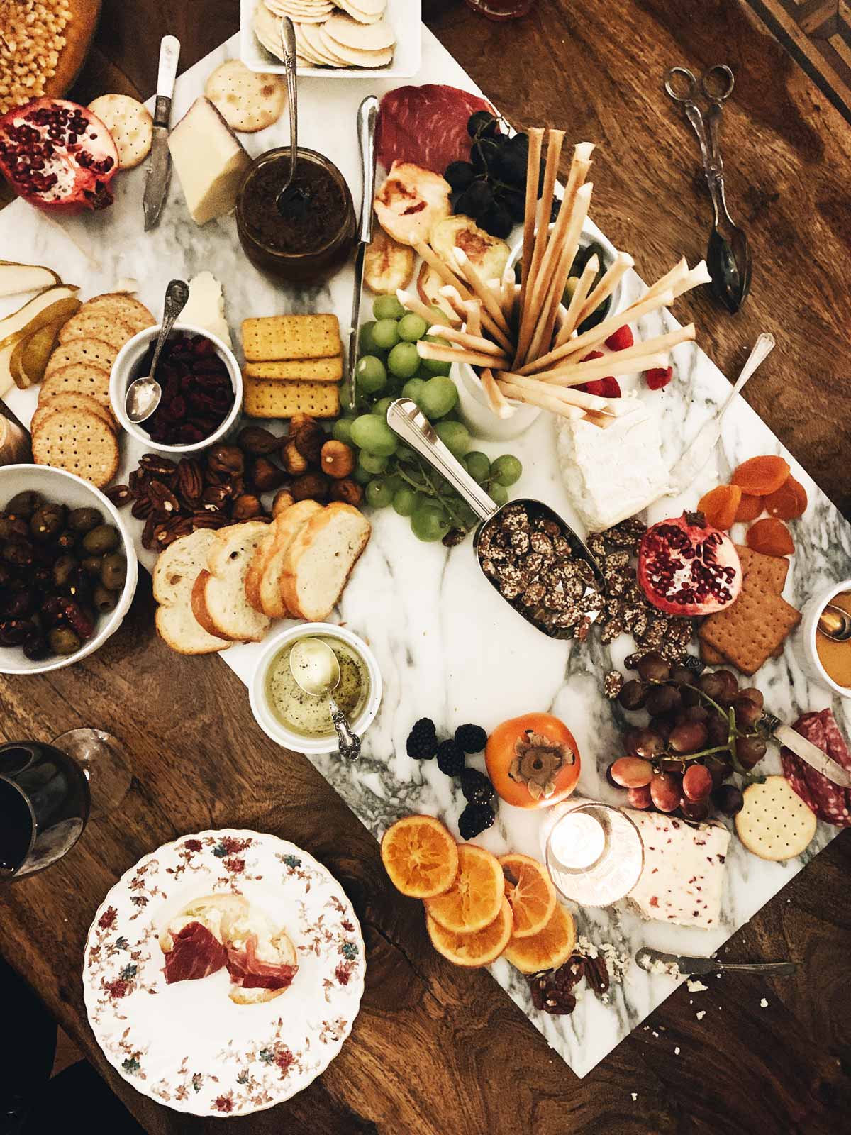 a large charcuterie board on a table with wine