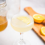 honey lemon gimlet cocktail with lemon wedge