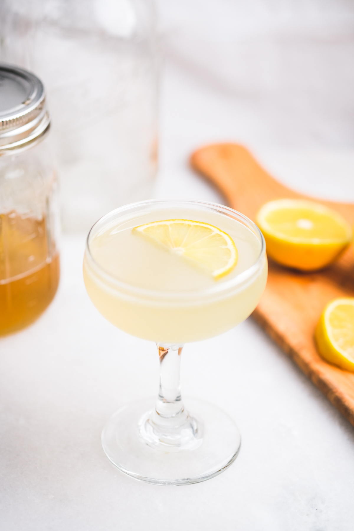 honey lemon gimlet cocktail with lemon wedge