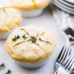 mini chicken pot pies in ramekins with thyme garnished on top