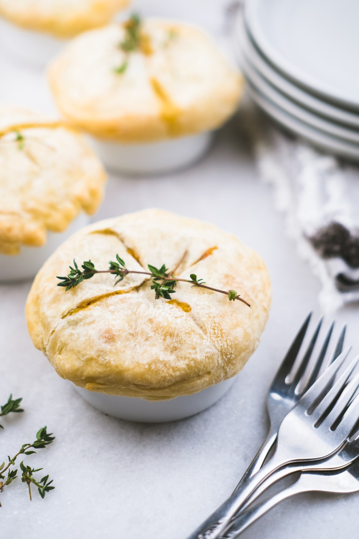 mini chicken pot pies in ramekins with thyme garnished on top