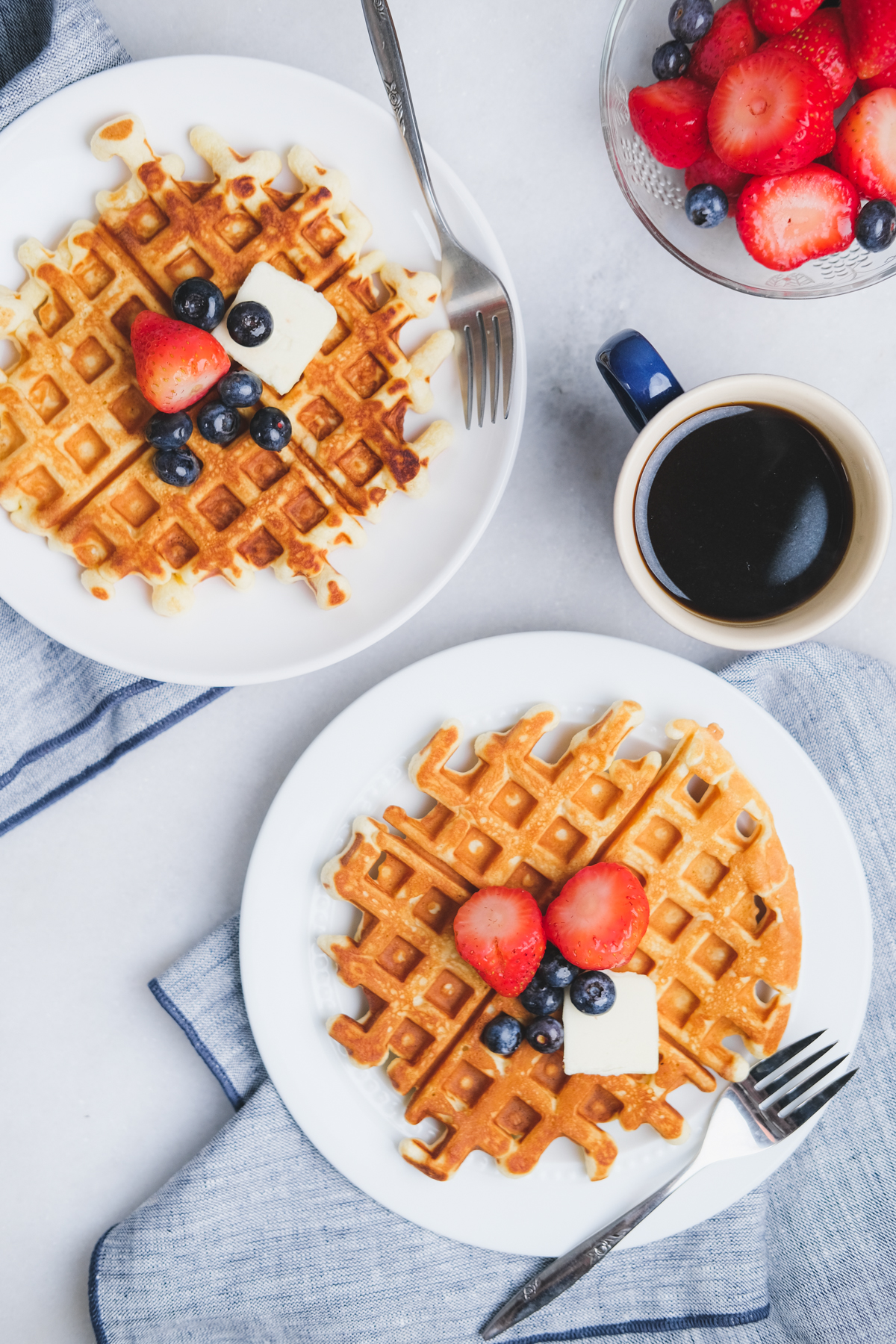 old fashioned waffles with berries and butter on a breakfast table