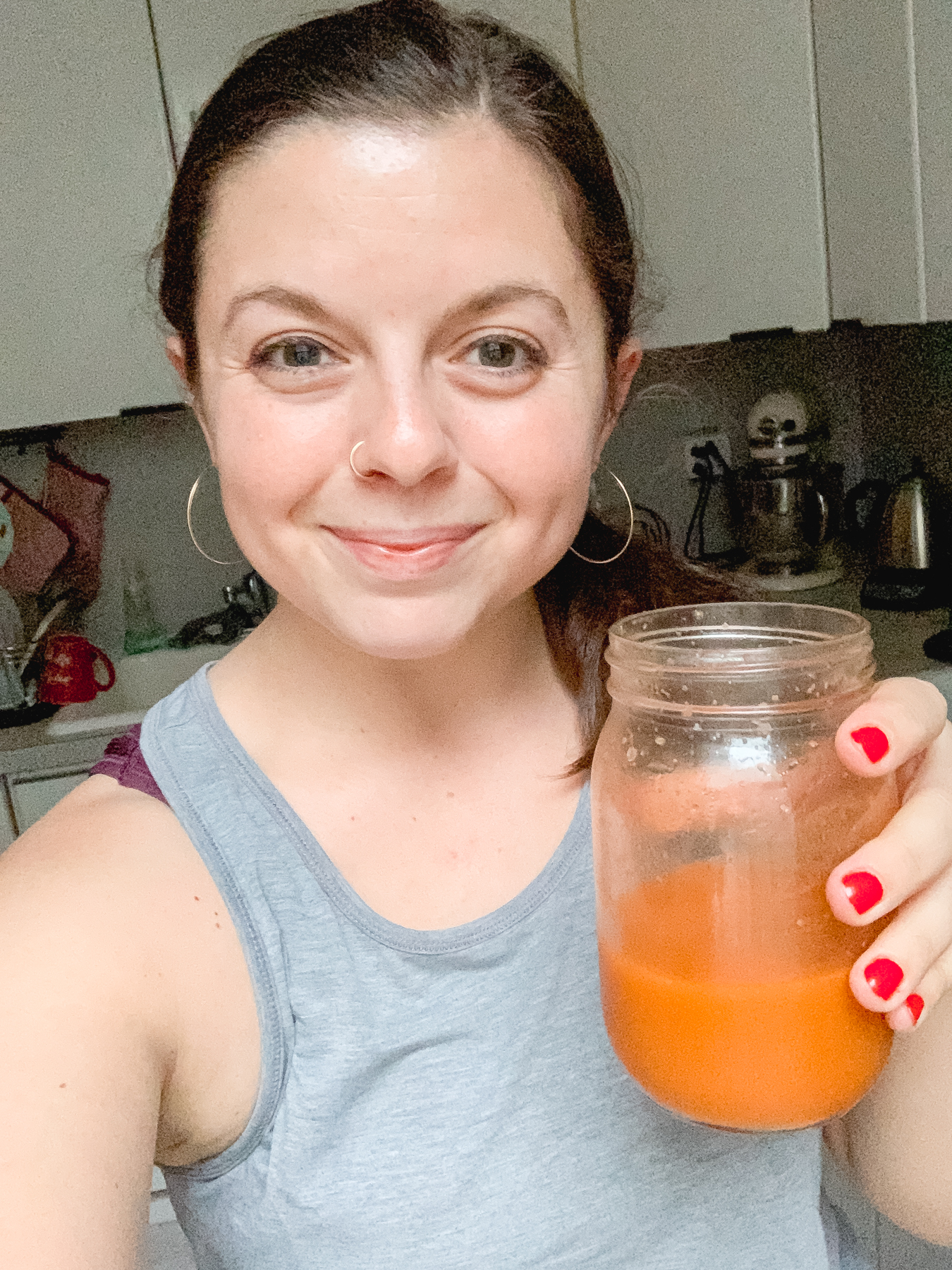 holding a jar of homemade carrot celery juice