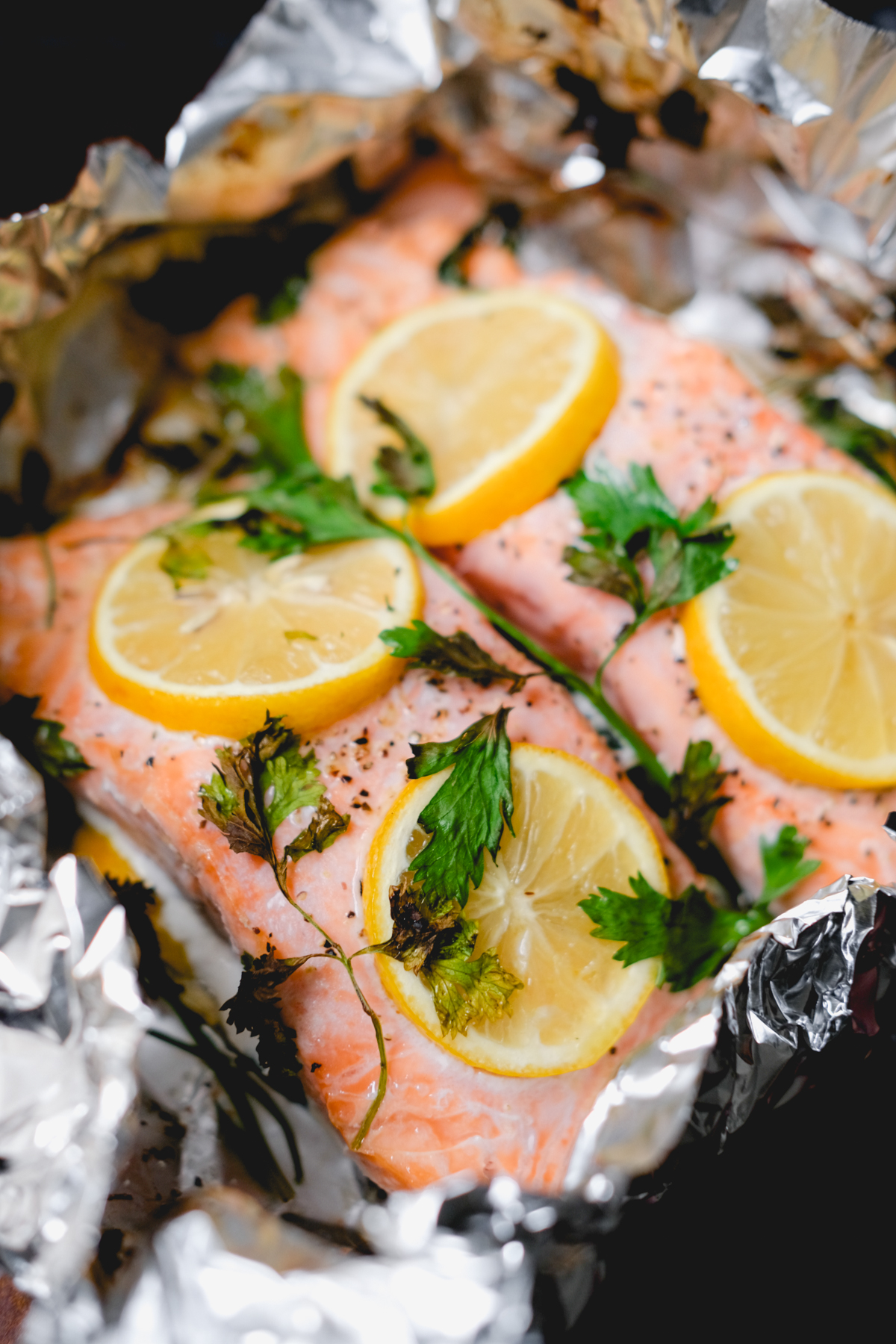 baked salmon with lemon slices and parsley in foil