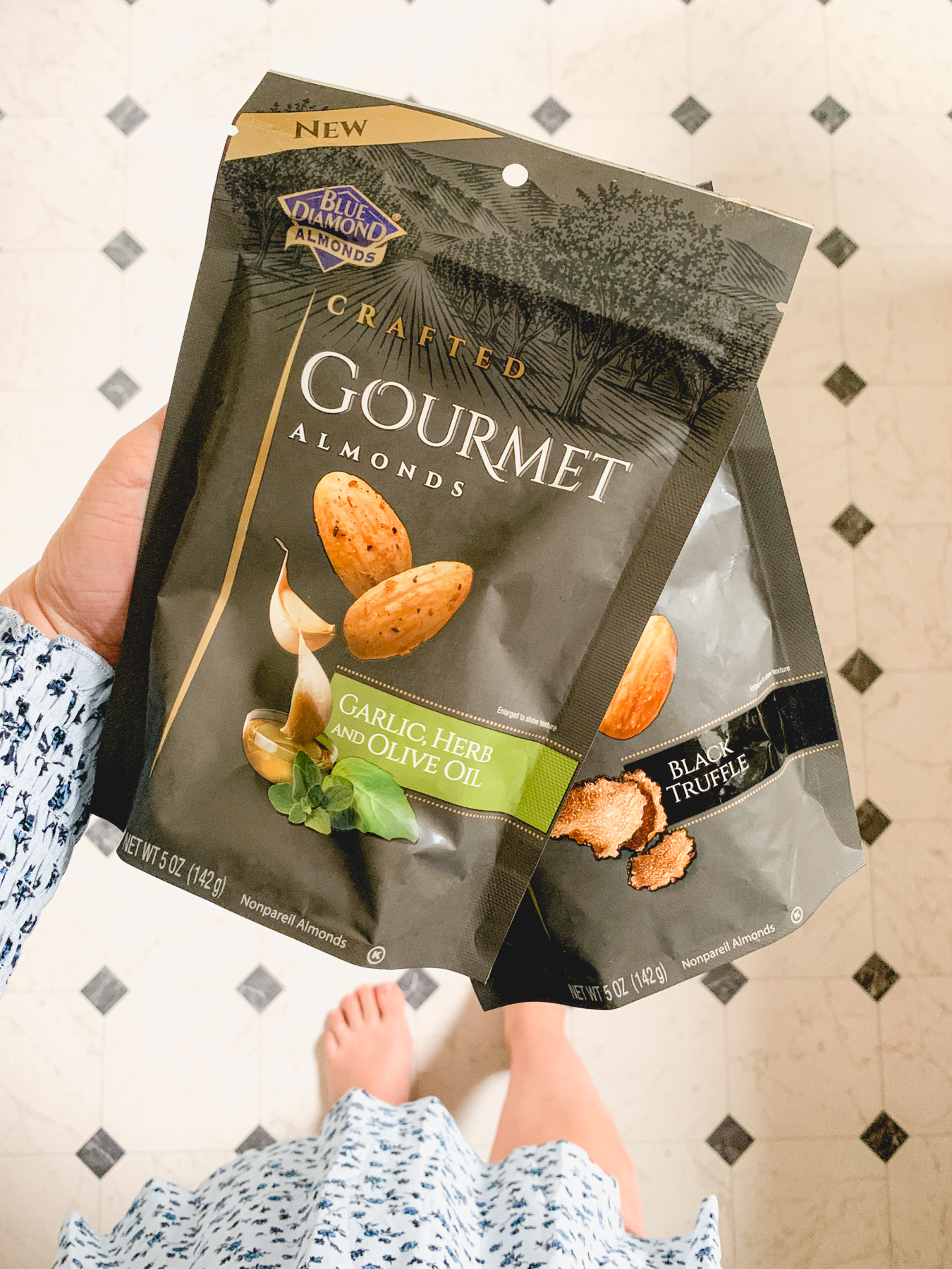 holding two bags of blue diamond gourmet almonds