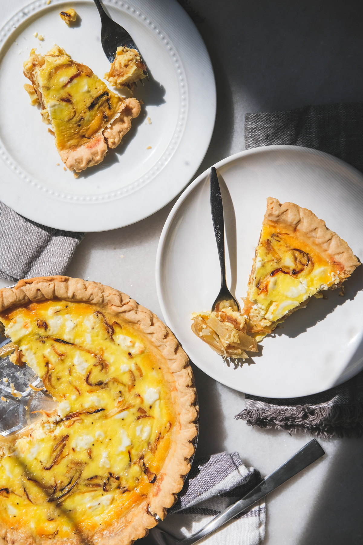slices of caramelized onion and goat cheese quiche on a breakfast table