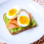 avocado toast with slices of smoked salmon and a soft boiled egg