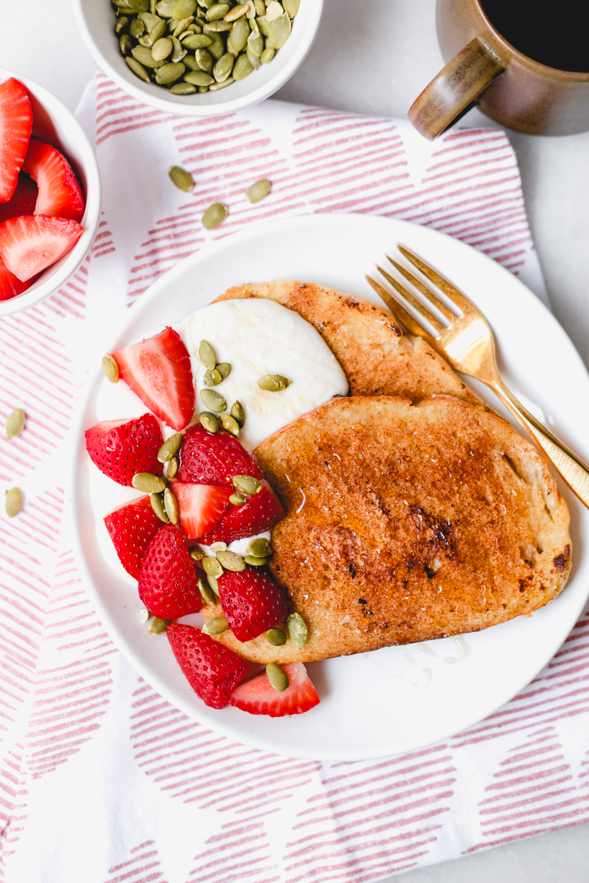 slices of french toast with honey whipped ricotta strawberries and pumpkin seeds