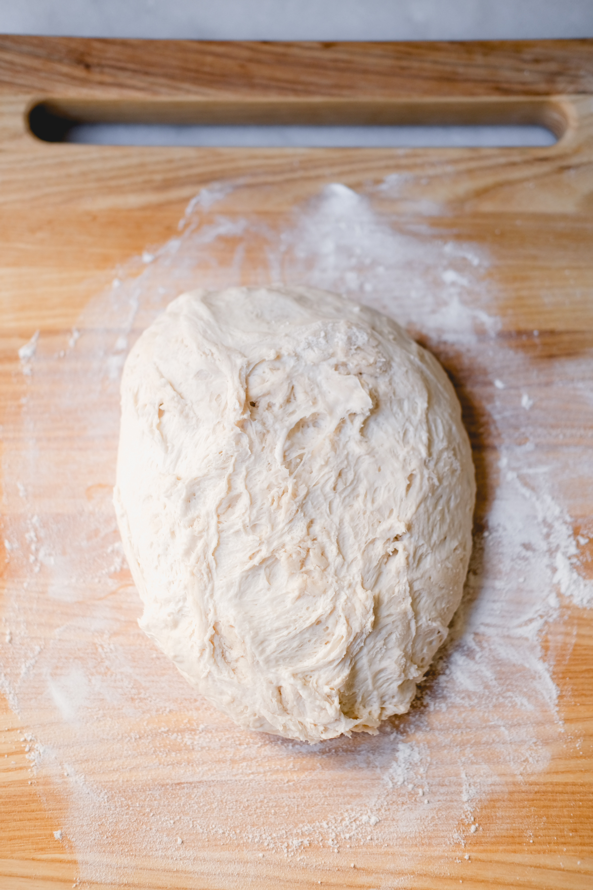 transferring sourdough bread dough to a floured surface to rest for 5 minutes