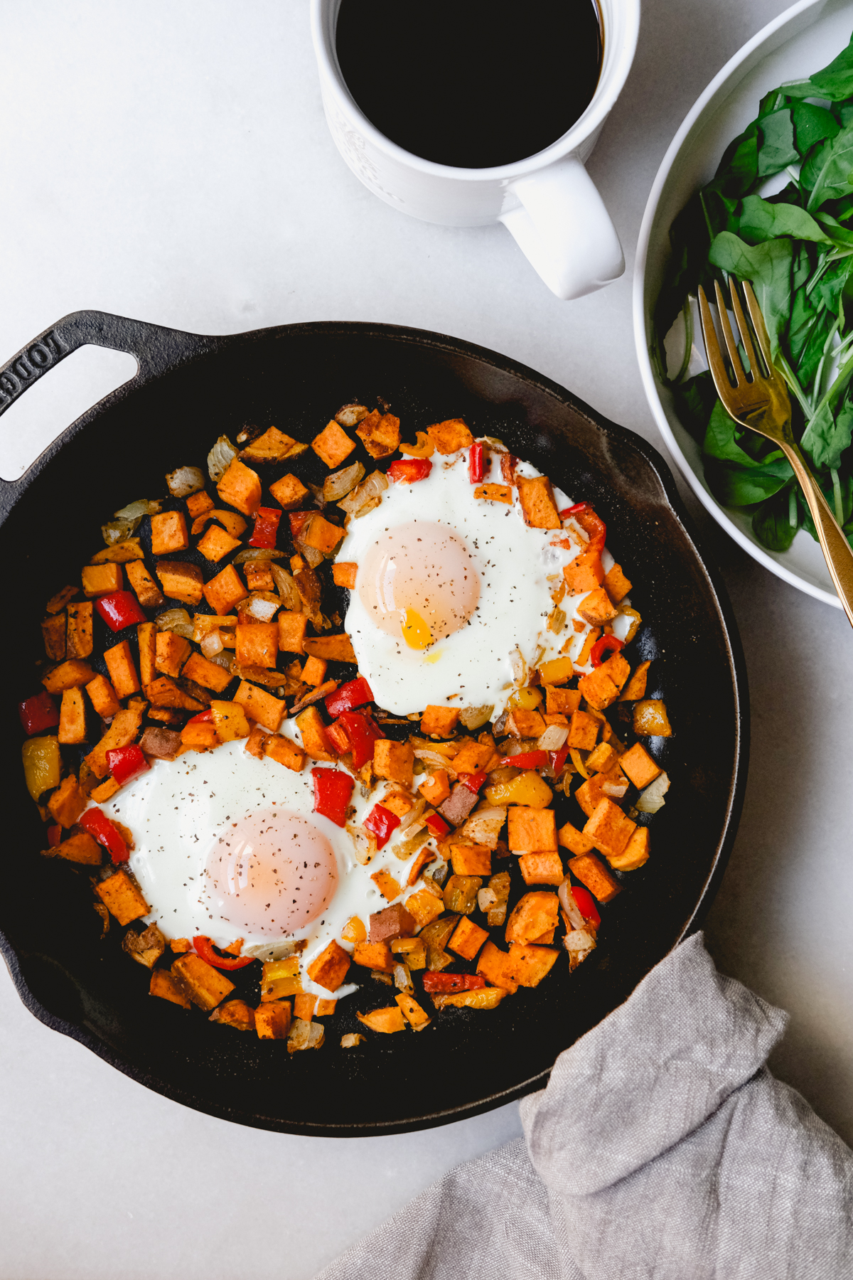 roasted sweet potato hash with eggs cooked in a cast iron skillet