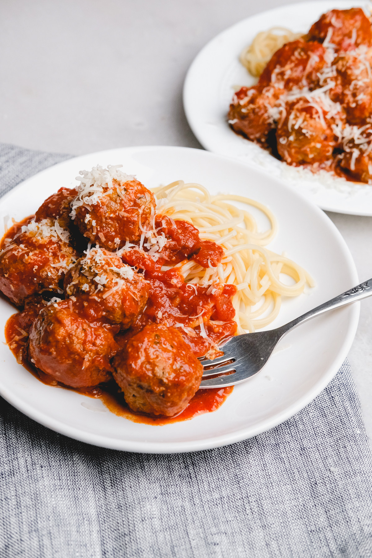 Italian meatballs on a plate with spaghetti and cheese